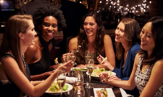 Group of young women chatting over a meal at a trendy restaurant
