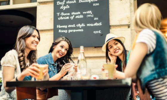 Group of young women chatting over a drink at a trendy bar